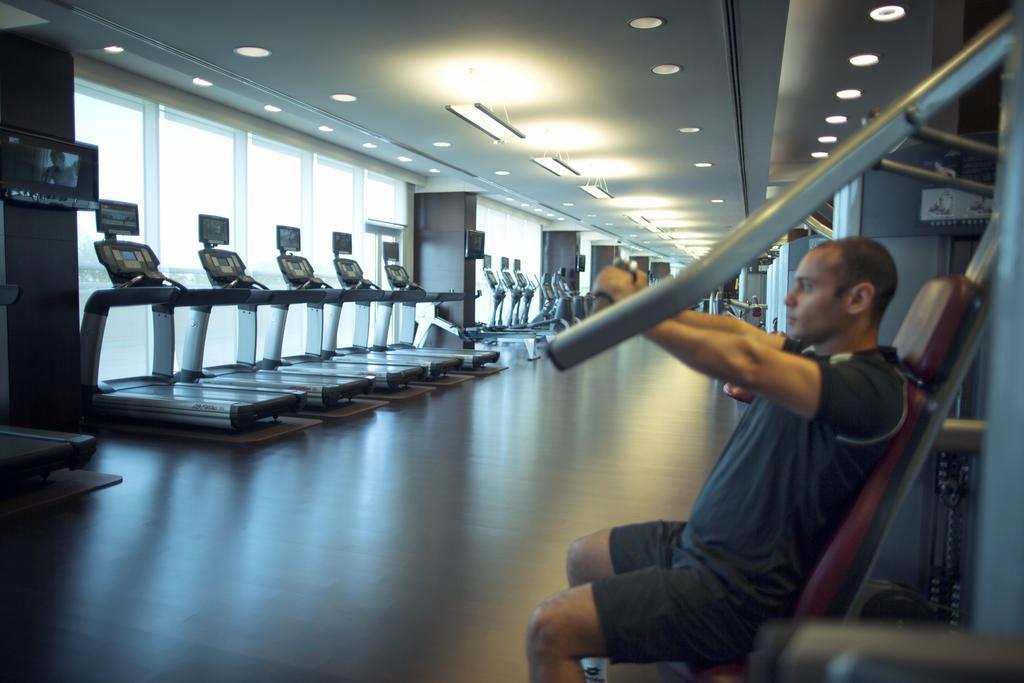Hotel Hyatt Regency Oryx Ad Dawhah Esterno foto A man using a lat pulldown machine